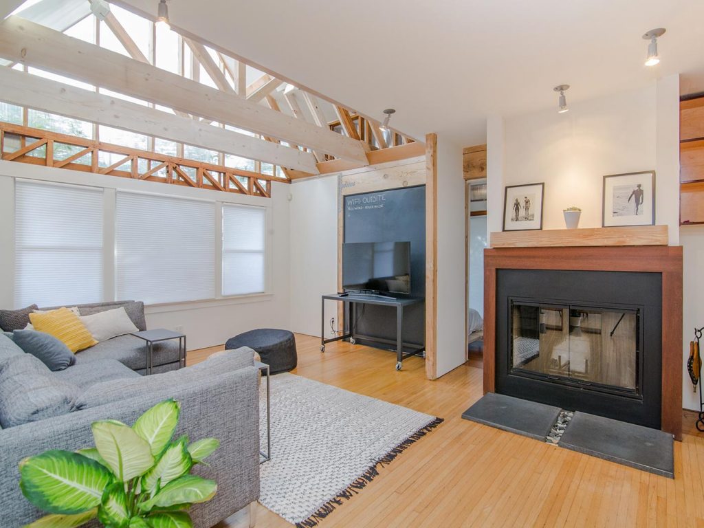Renewable energy green home with a grey sofa, and natural lighting through the beams